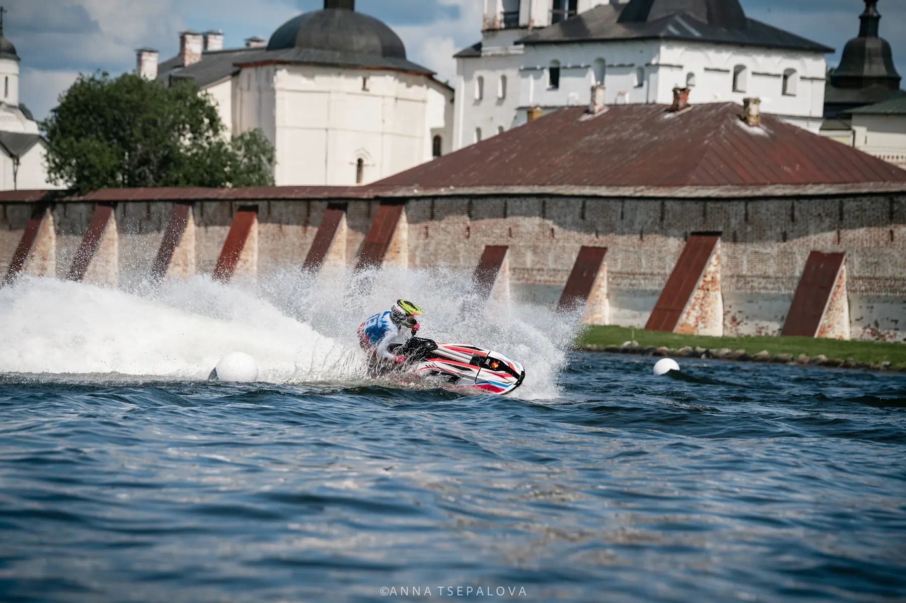 Eva races her aquabike beside a historic embankment